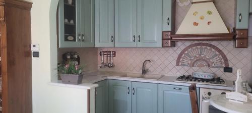 a kitchen with blue cabinets and a sink and a stove at Bed & Breakfast da Giovanni in Alessano