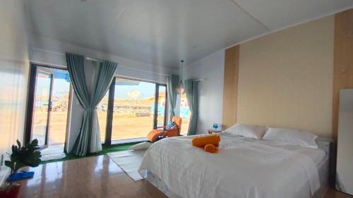 a bedroom with a large bed and a large window at Long Vĩ hotel - đảo Phú Quý in Cu Lao Thu