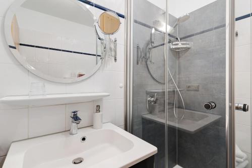 a bathroom with a sink and a shower with a mirror at Appartement Im Hof, 36qm in Schenkenzell