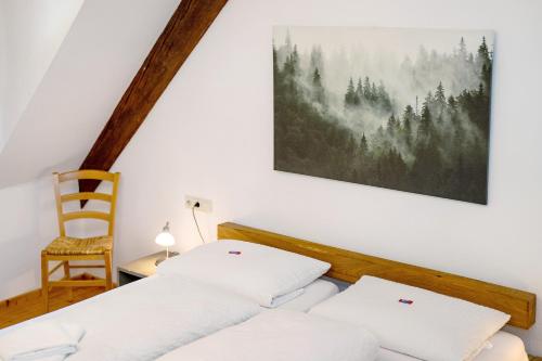 a bedroom with two beds and a chair at Appartement Im Hof, 36qm in Schenkenzell
