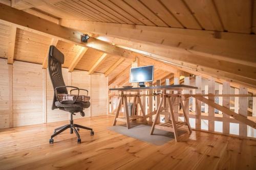 a room with a desk and a computer in a attic at Casa do Sol Nascente in Foz do Arelho