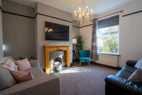 a living room with a couch and a fireplace at Spacious Town House in Lytham St Annes