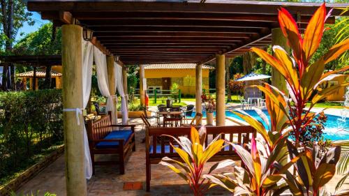 un patio con sillas y sombrillas y una piscina en Recanto 3ELLL en Bodoquena