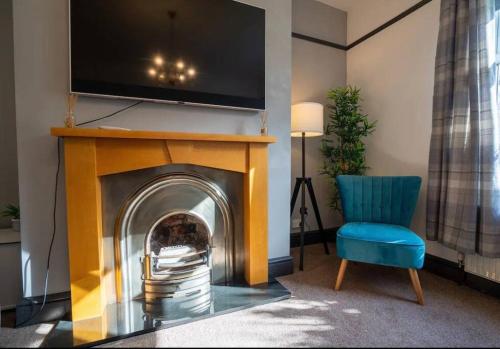 a living room with a fireplace with a tv above it at Spacious Town House in Lytham St Annes