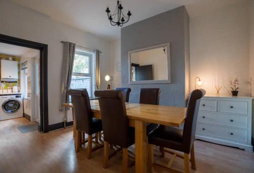 a dining room with a wooden table and chairs at Spacious Town House in Lytham St Annes