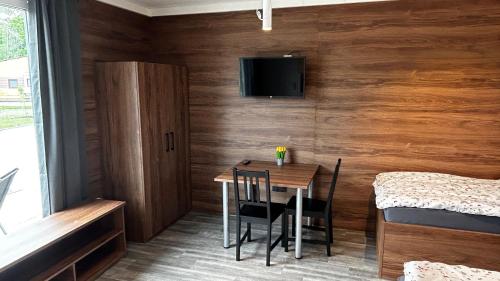 a small room with a table and chairs and a tv at Apartmány Štramberk in Štramberk