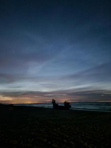 a person sitting on a boat on the beach at Domki i pokoje u Izabeli in Sztutowo