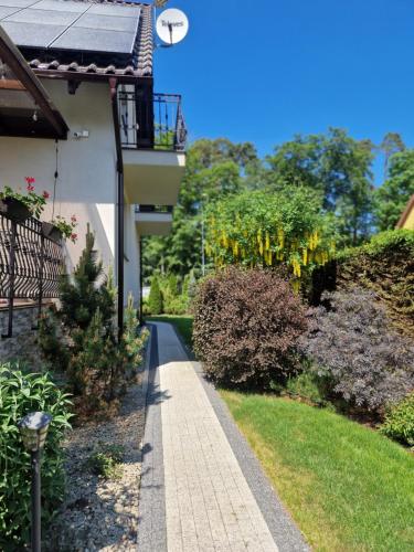 a walkway next to a house with a balcony at Domki i pokoje u Izabeli in Sztutowo