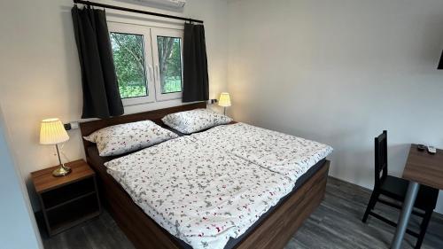 a small bedroom with a bed and a window at Apartmány Štramberk in Štramberk