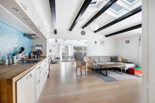 a kitchen and living room with a couch and a table at Lovely Bright Summer House Close To The Beach in Rødvig