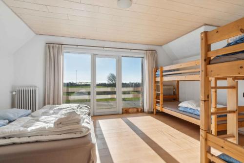 a bedroom with two bunk beds and a large window at House For 40 People Near Thy in Gettrup