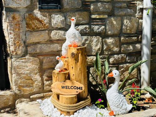 un groupe de canards assis sur des poteaux en bois avec un signe de bienvenue dans l'établissement Villa Anfora, à Datça