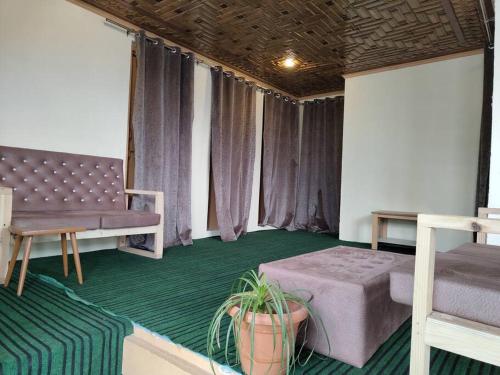 a room with a bed and a couch and a table at Green House with kitchen in Srinagar