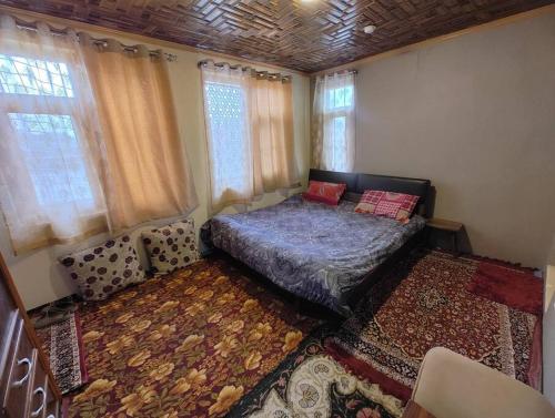 a bedroom with a bed and a rug at Green House with kitchen in Srinagar