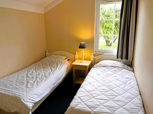 ein kleines Schlafzimmer mit zwei Betten und einem Fenster in der Unterkunft Alouette Piscines chauffees in Saint-Hilaire-de-Talmont