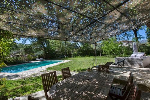 un patio avec une table et des chaises à côté d'une piscine dans l'établissement Villa Ycee Ondo, à Roquefort-les-Pins