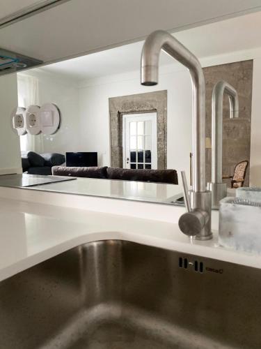 a kitchen with a sink in front of a mirror at CASA de FORO - Apartamentos Turísticos in Angra do Heroísmo
