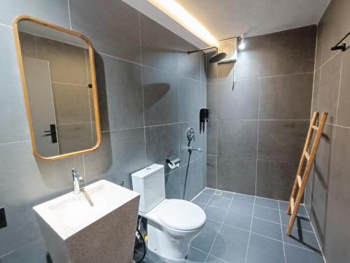 a bathroom with a toilet and a sink and a mirror at FX Stay & Coffee in Yogyakarta