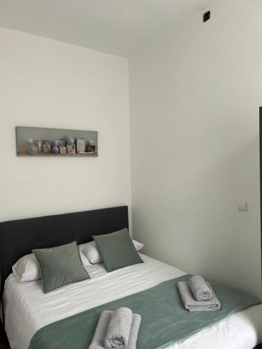 um quarto com uma cama grande e toalhas em Charmant T2 centre ville em Givet