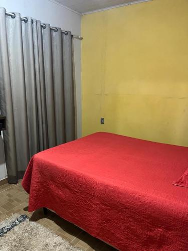 ein Schlafzimmer mit einem Bett mit einer roten Decke in der Unterkunft Apt Rondônia rual show in Ji-Paraná