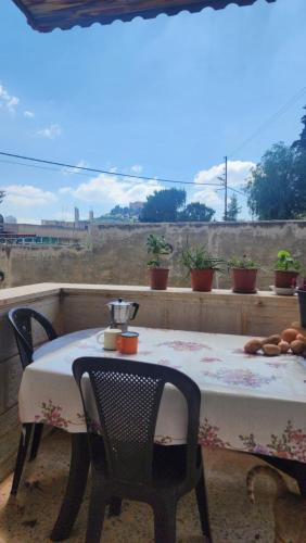 a table and chairs on a balcony with a view of a field at Blackbird Sanctuary homestay & Art Cafe in Ajloun