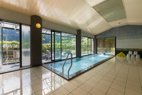 duży kryty basen ze szklanymi oknami i duży basen w obiekcie Ichinomata Onsen Kanko Hotel w mieście Shimonoseki