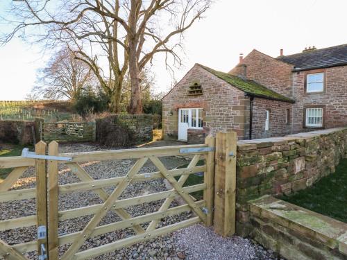 a wooden gate in front of a brick house at Luham Cottage in Penrith