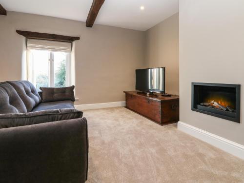 a living room with a couch and a flat screen tv at Luham Cottage in Penrith
