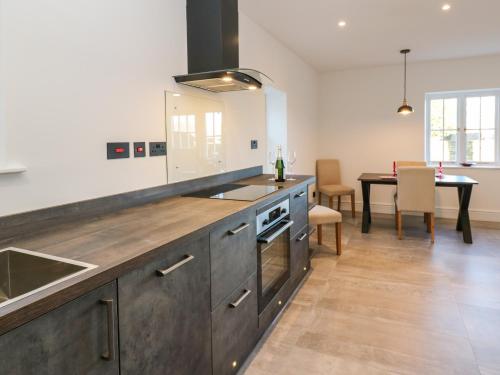a large kitchen with a sink and a table at Luham Cottage in Penrith