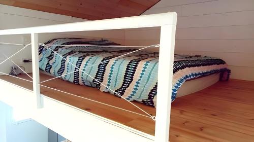 Ce lit superposé blanc se trouve dans une chambre mansardée. dans l'établissement La Fourmi - Maison avec piscine à Lacanau Lac, à Lacanau