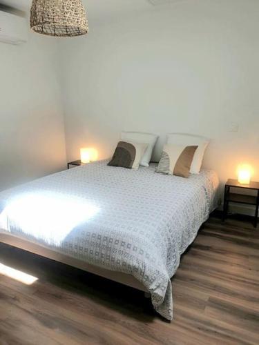 une chambre avec un grand lit blanc avec deux lampes dans l'établissement Orvilliers, à Moulins