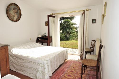 une chambre avec un lit et une porte coulissante en verre dans l'établissement Villa Perdrix, à Grimaud