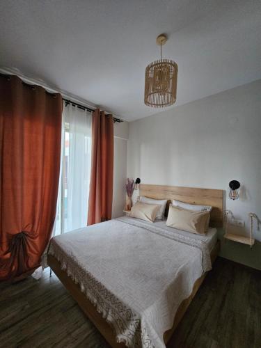 a bedroom with a large bed with an orange curtain at Marivar living in Nea Fokea
