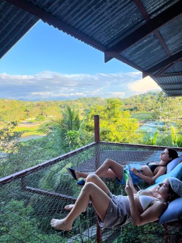 two people laying on the viewing platform of a tree house at Villas Jacquelina in Quepos