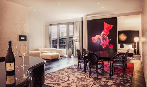 a living room with a table and chairs and a couch at Kameha Grand Bonn in Bonn