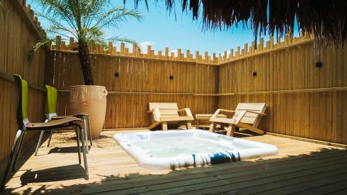 a hot tub on a patio with chairs and a fence at La Ardilla de Santa Fe by Bernalo Hotels in Santa Fe de Antioquia