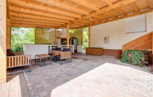 an outdoor patio with a wooden ceiling and a table at 3 Bedroom Cozy Home In Stari Brod in Stari Brod