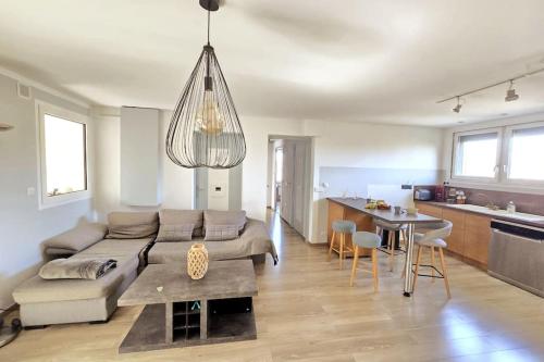 un salon avec un canapé et une table et une cuisine dans l'établissement Le Belvédère + Clim + Extérieur + Parking Gratuit, aux Angles (Gard)