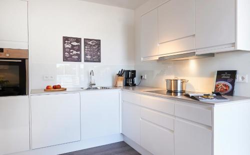エッカーンフェルデにあるHafenspitzeの白いキッチン(白いキャビネット、電化製品付)