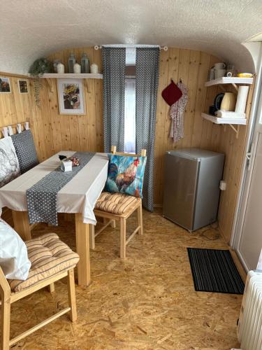 a dining room with a table and chairs in a room at Horská maringotka na farmě in Klíny