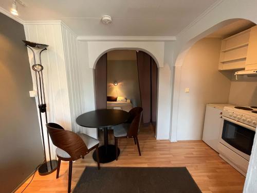 een kleine keuken met een tafel en stoelen in een kamer bij Enter Backpack Hotel in Tromsø