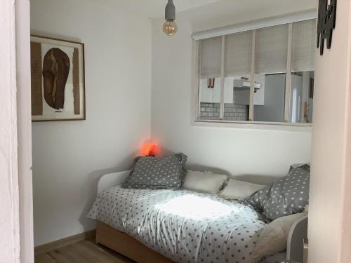 une petite chambre avec un lit et une fenêtre dans l'établissement La Bohème, à Rochefort