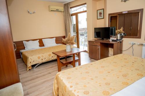 a hotel room with two beds and a television at Lucky Hotel in Veliko Tŭrnovo