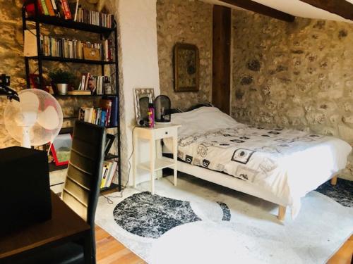 une chambre avec un lit et une étagère dans l'établissement Beau studio indépendant pour 2 personnes dans village provençale, à Salles-sous-Bois