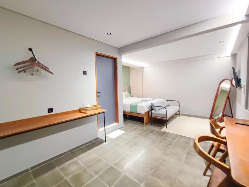 a room with a bed and a desk and a bedroom at FX Stay & Coffee in Yogyakarta