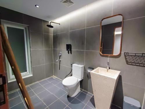 a bathroom with a toilet and a sink and a mirror at FX Stay & Coffee in Yogyakarta
