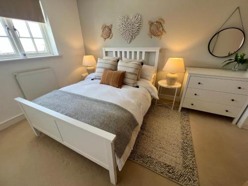 a bedroom with a large white bed with two lamps at Manuka Cottage, stylish property with hot tub in Stoke Gabriel