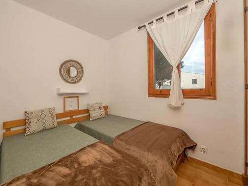 une chambre avec deux lits et une fenêtre dans l'établissement Xaloc , apartamento con piscina y junto la playa, à Arenal d'en Castell