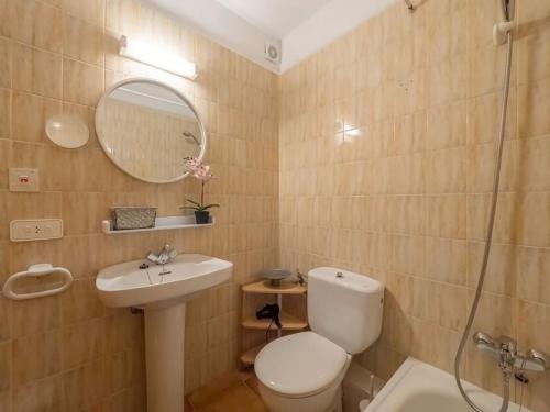 une salle de bain avec toilettes, lavabo et miroir dans l'établissement Xaloc , apartamento con piscina y junto la playa, à Arenal d'en Castell