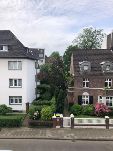 杜塞道夫的住宿－Rhein-Flair，享有两栋房屋和花园的景致。